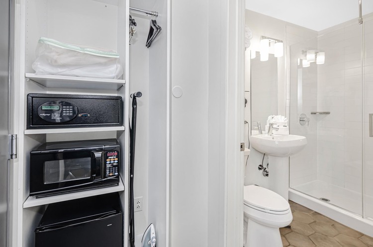Safe, microwave, mini fridge, and closet beside bathroom