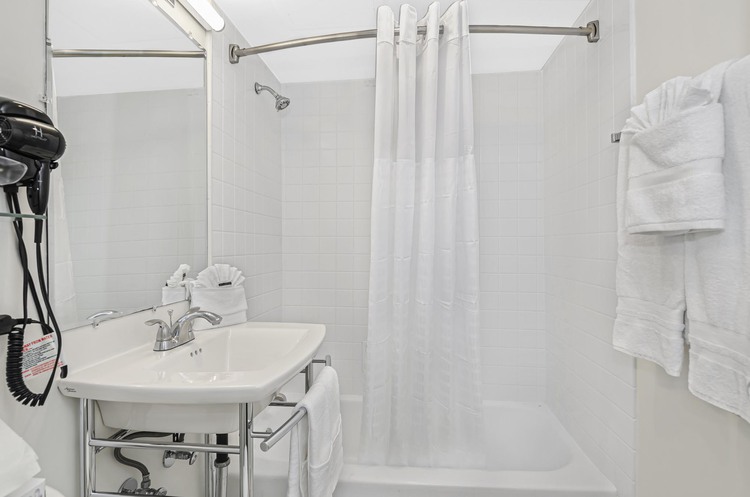 Bathtub, shower curtain, vanity and toilet