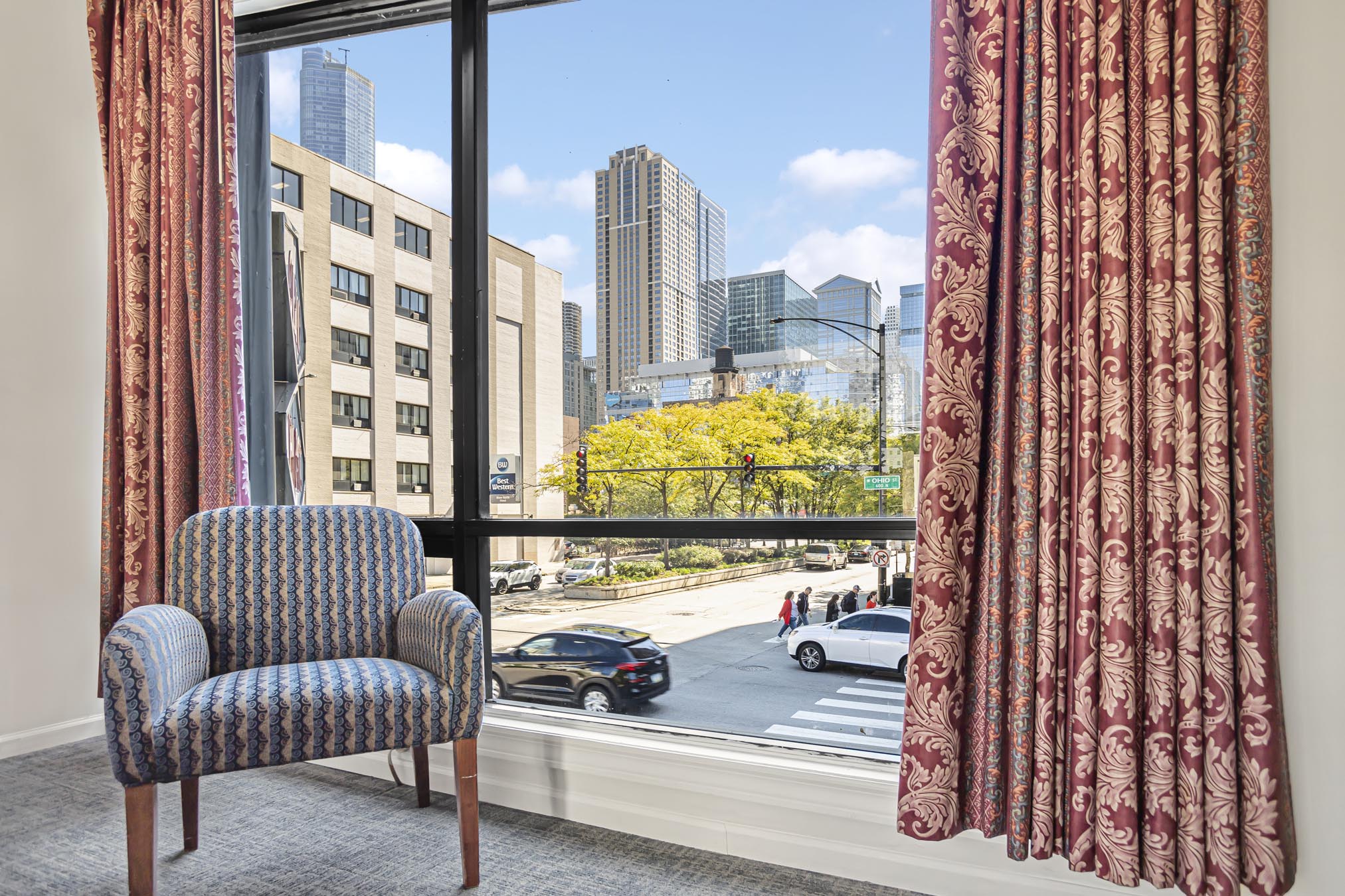 Patterned armchair in front of window overlooking city